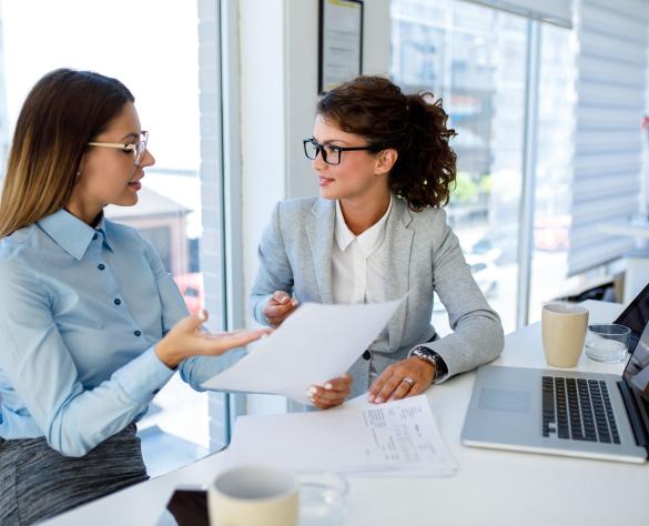 Businesswomen with laptop cooperating at work