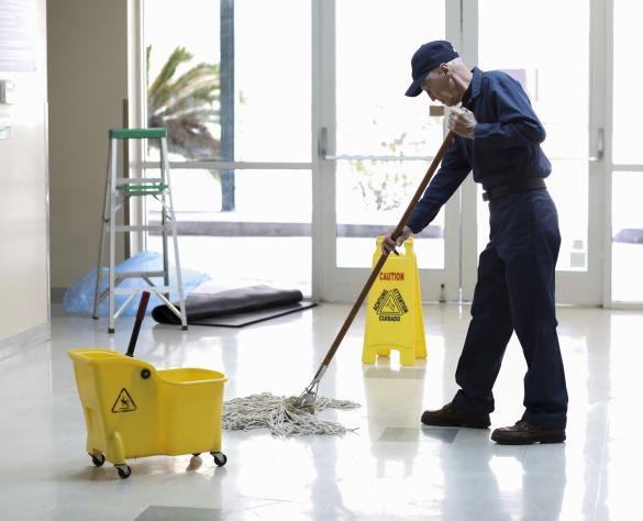 Senior adult Janitor keeps the floors cleaned and sanitized due to the virus.